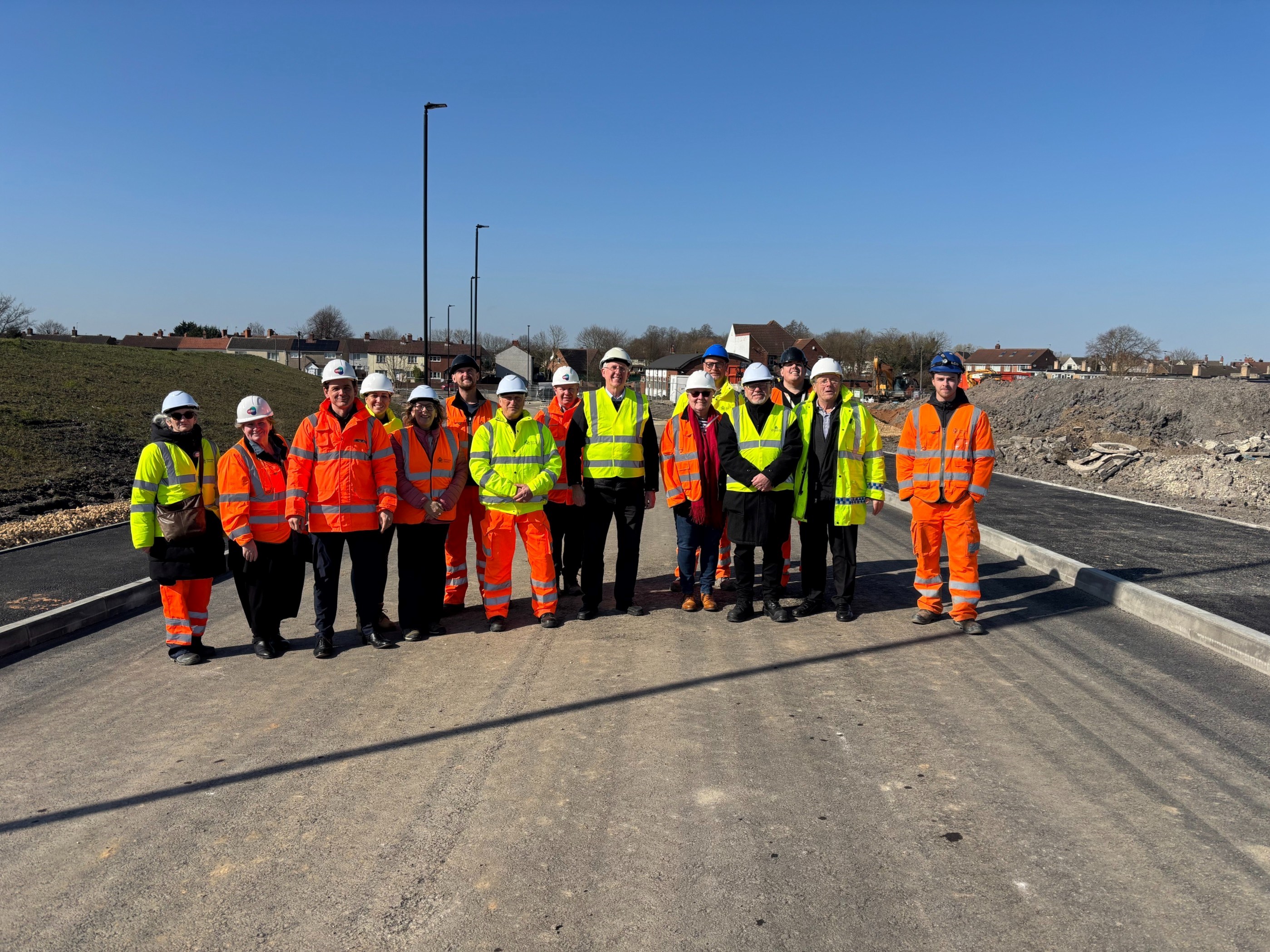 Delegates pose for a photo on the site of the new link road 