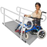 A person in a wheelchair on an access ramp.