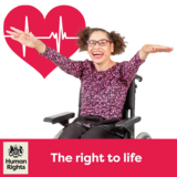 A person in a wheelchair looking happy in front of a red heart with a heartbeat inside it.